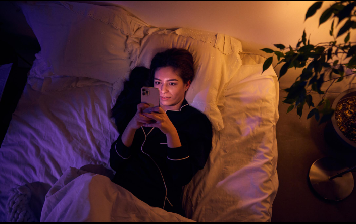 Blue light from a smartphone affecting sleep in a modern bedroom